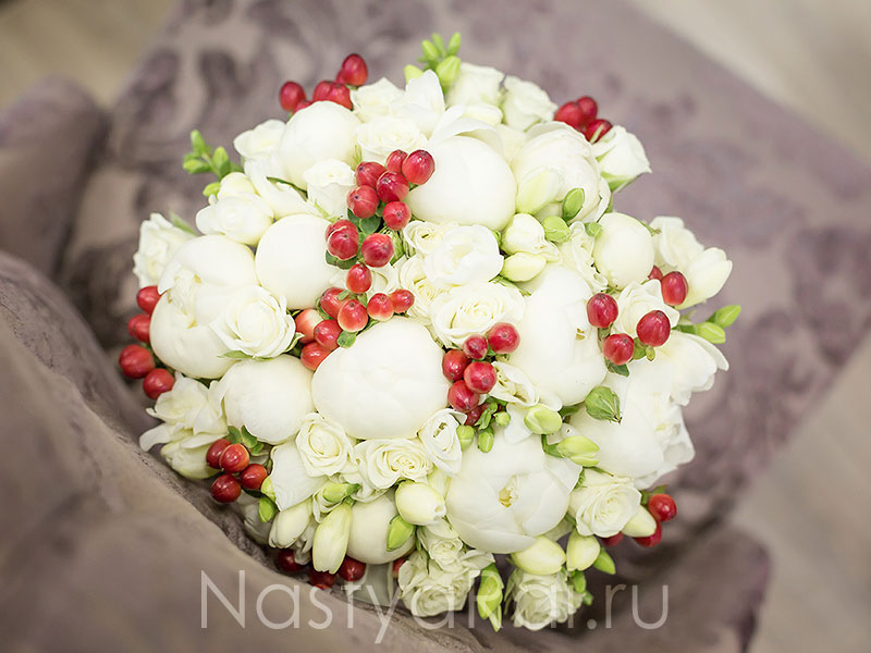 Фото. Букет невесты из белых пионов с ягодами.