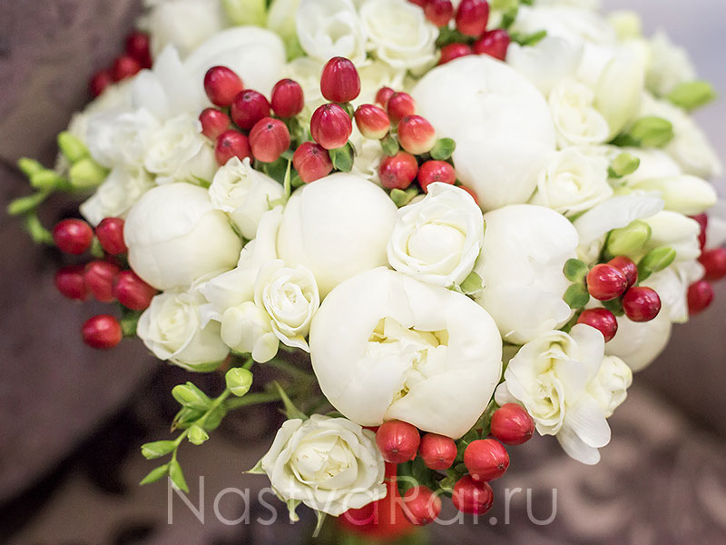 Фото. Букет невесты из белых пионов с ягодами.